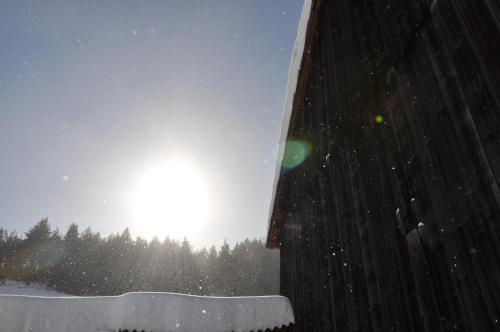 a snow covered building with the sun in the background at DVOR POD KRíKMI in Spišský Štvrtok