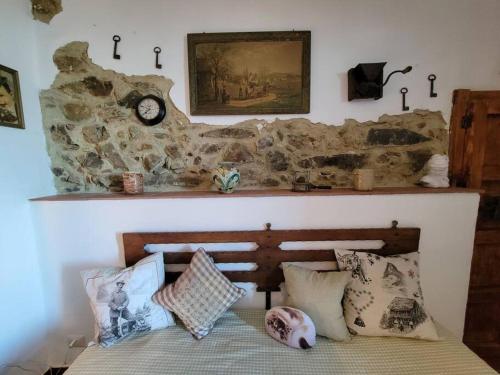 a bedroom with a stone wall with a bed with pillows at Appartamento Timo in Acquedolci