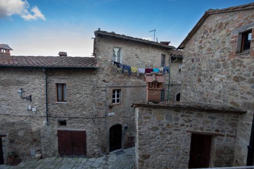 an old stone building with clothes drying on a clothes line at La Casetta Nel Borgo in Castelnuovo di Val di Cecina