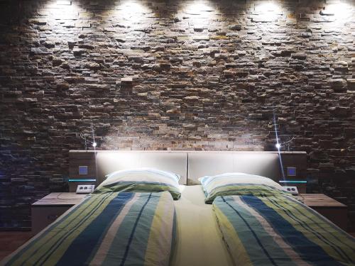 a bedroom with two beds and a brick wall at Ferienwohnung Botschafter in Wendelstein