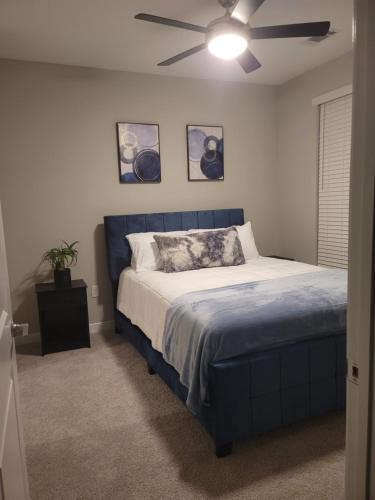 a bedroom with a blue bed and a ceiling fan at Short term rental in Charlotte