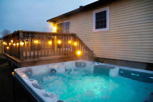 a hot tub on a deck next to a house at NEW! Updated Mystic Home w/ Sauna, Hot Tub & Deck in Mystic