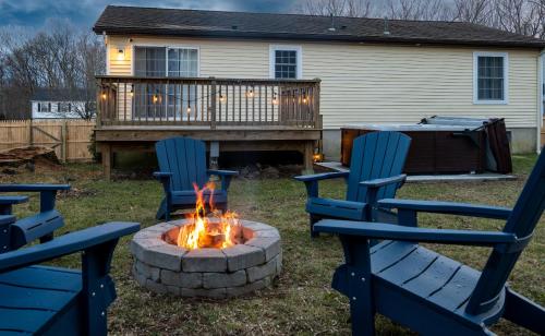 two blue chairs and a fire pit in a yard at NEW! Updated Mystic Home w/ Sauna, Hot Tub & Deck in Mystic