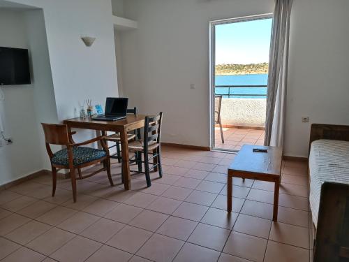 ein Wohnzimmer mit einem Tisch und einem Laptop darauf in der Unterkunft 9 Muses Apartments in Agios Nikolaos