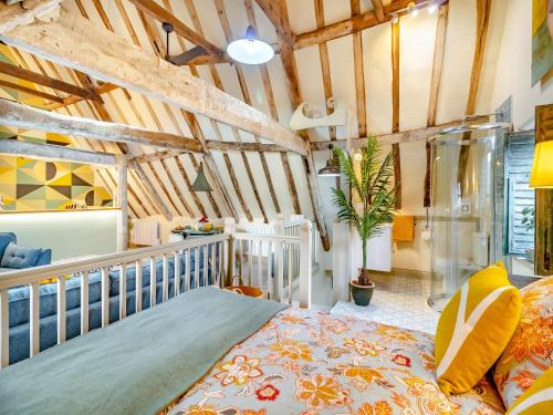 a bedroom with a bed in a room with wooden ceilings at Haberdashers Loft in Bungay