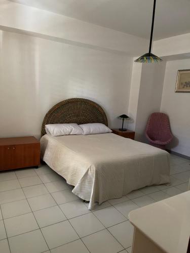a bedroom with a large bed and two chairs at Tecla appartamento in Acireale