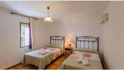 a bedroom with two beds and a window at Casa Rural la Joya in Iznájar