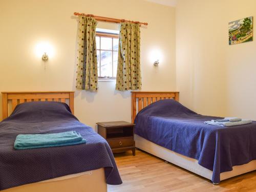 um quarto com 2 camas e uma janela em Dragonfly - Uk42521 em Aldwincle Saint Peter