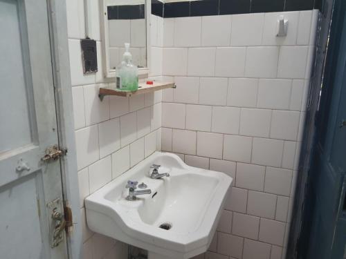 a white bathroom with a sink and a mirror at Casa piedra cartagena in Cartagena