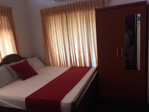Yaarl Holiday في جافنا: غرفة نوم بسرير وبطانية حمراء وبيضاء