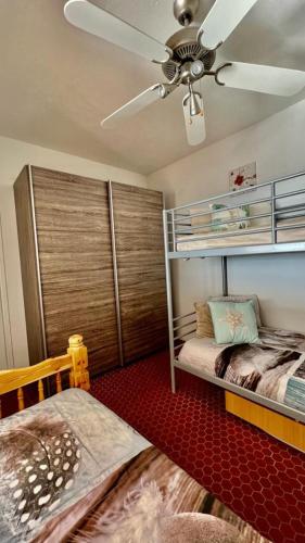 une chambre avec deux lits superposés et un ventilateur de plafond dans l'établissement Résidence Katikias - vue mer, à Bandol