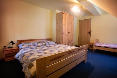 1 dormitorio con 1 cama y armario de madera en Apartmány Javořinka en Pec pod Sněžkou