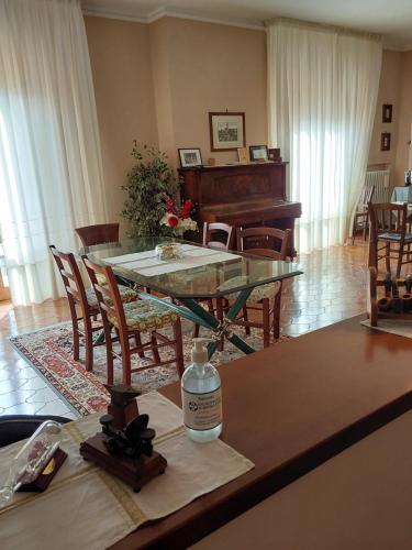 a living room with a table and a piano at La Casa di Enrico in San Quirico dʼOrcia