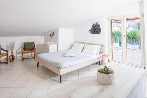 una camera bianca con un letto e una sedia di MARCHE FULL EXPERIENCE-Apartments a Porto SantʼElpidio