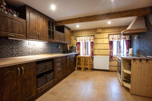 a kitchen with wooden cabinets and a counter top at Apartmány Javořinka in Pec pod Sněžkou