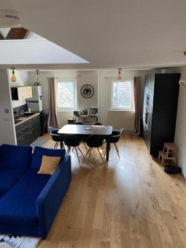 un salon avec un canapé bleu et une table dans l'établissement Appartement duplex centre Dieppe-Le perchoir St Jacques-3 chambres, à Dieppe