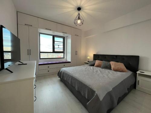 Un dormitorio con una cama grande y una ventana en City View Apartament en Iaşi