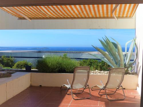 2 sillas sentadas en un patio con una planta en Résidence Katikias - vue mer, en Bandol