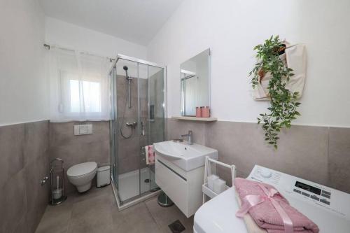 a bathroom with a sink and a shower and a toilet at Apartment Fiorino in Zadar