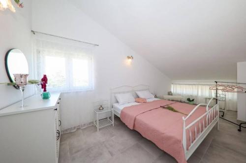 a white bedroom with a bed with a pink blanket at Apartment Fiorino in Zadar