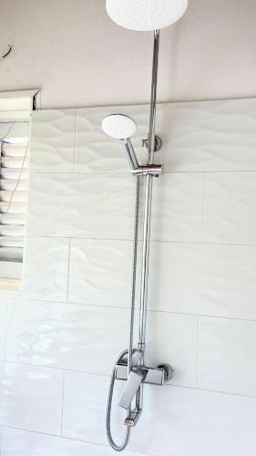 a shower light in a bathroom with white tiles at Playa Bonita 4 minute walk from our private Villa Anantara Bonita in Las Terrenas