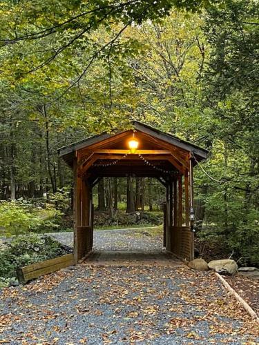 a wooden bridge in the middle of a forest at Peaceful Gateway to Island Creek Cottage in East Stroudsburg