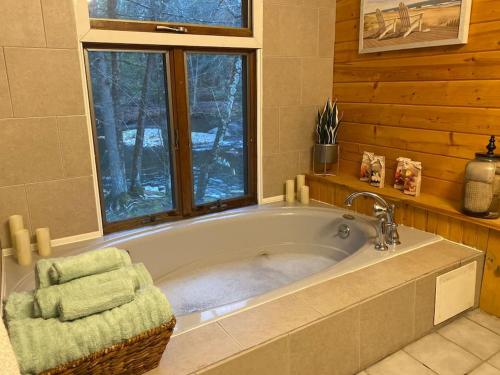 bañera grande en una habitación con ventana en Peaceful Gateway to Island Creek Cottage, en East Stroudsburg