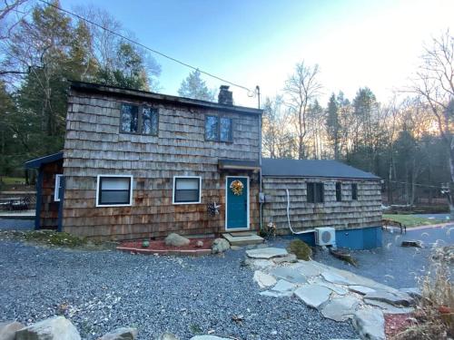 a small wooden house with a blue door at Peaceful Gateway to Island Creek Cottage in East Stroudsburg