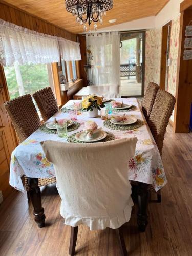 a dining room table with chairs and a table with dishes on it at Peaceful Gateway to Island Creek Cottage in East Stroudsburg
