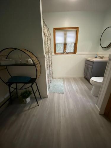 a bathroom with a toilet and a sink and a window at Peaceful Gateway to Island Creek Cottage in East Stroudsburg