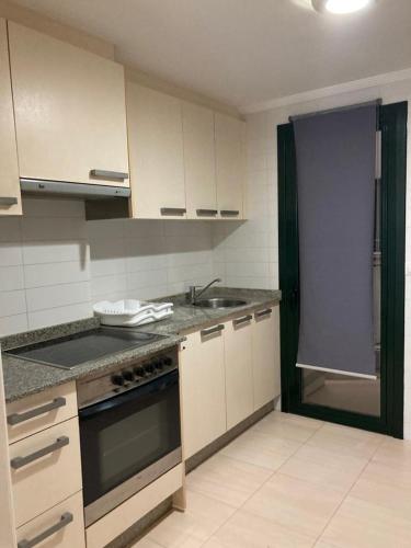 a kitchen with a sink and a stove top oven at FOZ II PLAYAS in Foz