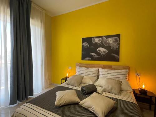 a bedroom with a large bed with a yellow wall at B&B D'Aponte Home in Volla