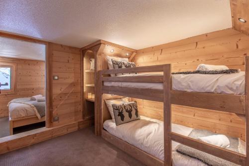 een slaapkamer in een blokhut met 2 stapelbedden bij Val Thorens - Cosy Duplex avec Vue Silveralp 338 in Val Thorens