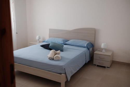 una camera da letto con un letto con due peluche sopra di Appartamento Maestrale a Torre Pali