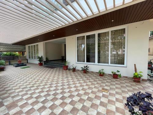 a patio with potted plants and a ceiling at Aikya Kadri #Your Home Away from Home# non Smoke# Vegetarians Preferred# Strictly for Families in Mangalore
