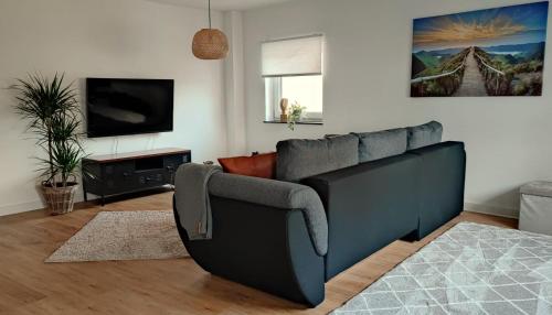 uma sala de estar com um sofá e uma televisão em Ferienhaus Polly em Taucha