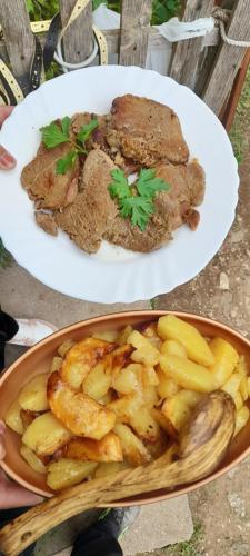 two plates of meat and potatoes on a table at Organic Family Farm in Žabljak