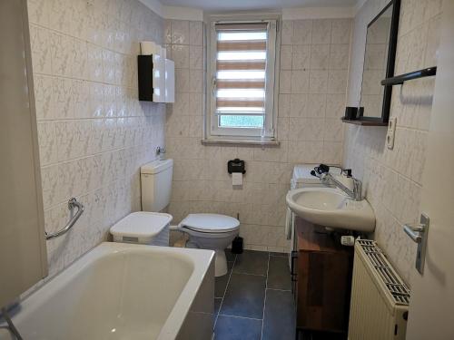 La salle de bains est pourvue d'une baignoire, de toilettes et d'un lavabo. dans l'établissement POLAT Apartments 4, à Essen
