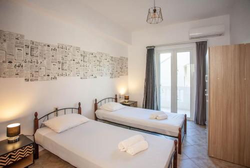 Un dormitorio con 2 camas y una pared con dibujos. en Retro seaside resort en La Canea