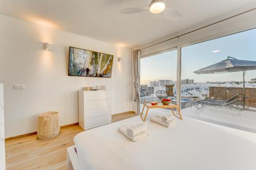 1 dormitorio con cama blanca y ventana grande en Calma Paraiso, en Playa Paraiso