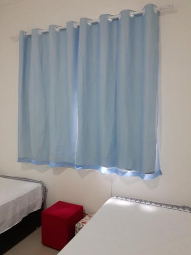 1 dormitorio con 2 camas y cortina azul en Apartamento Temporada Dalva Copacabana 2, en Río de Janeiro