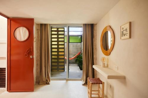 a hallway with a red door and a mirror at DADA JAJA by DW in San Juan
