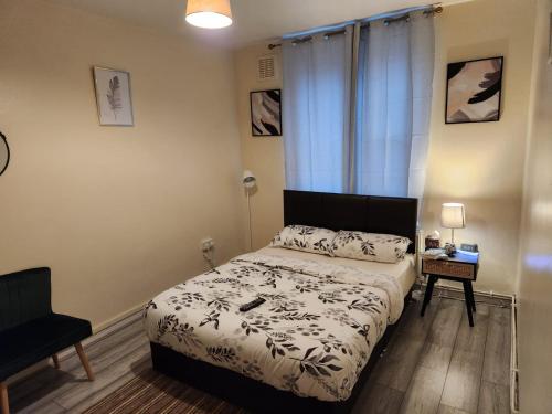 2-bedroom flat in Cutty-Sark, Greenwich ! في لندن: غرفة نوم صغيرة بها سرير وكرسي