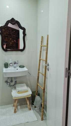 een badkamer met een ladder, een wastafel en een spiegel bij Casa do Adro da Igreja Velha in Janeiro de Cima