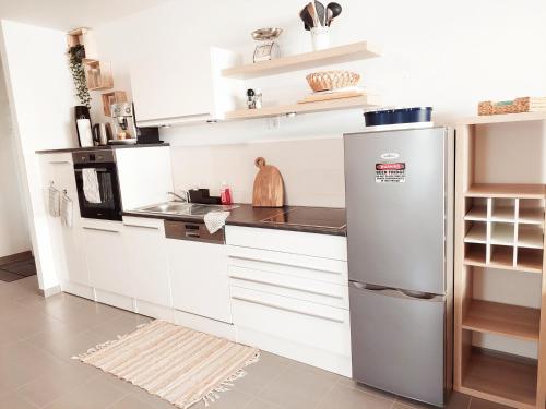 una cucina con armadietti bianchi e frigorifero di NewHome Nicole Premantura a Premantura