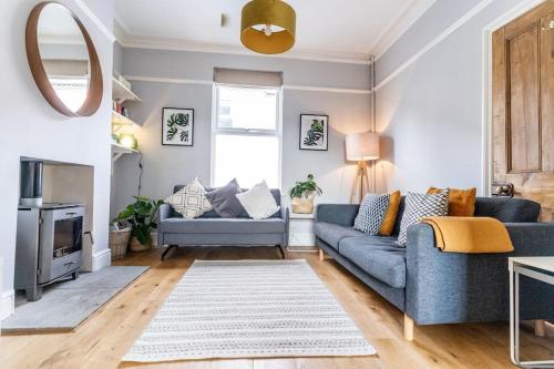 a living room with a blue couch and a mirror at Spacious 3 Bedroom House York in York