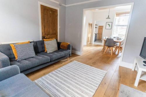 a living room with a blue couch and a table at Spacious 3 Bedroom House York in York