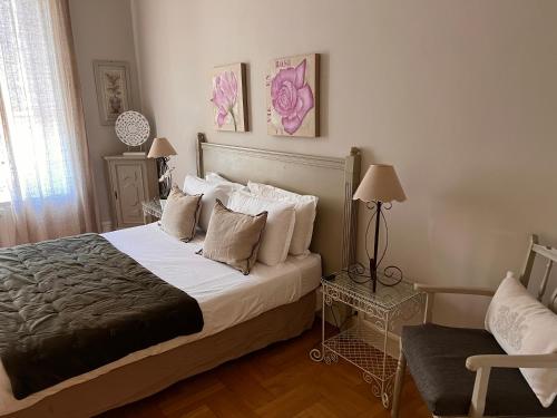 a bedroom with a large bed and a chair at Magnifique 2 pièces de 65m2 -quartier des Musiciens in Nice