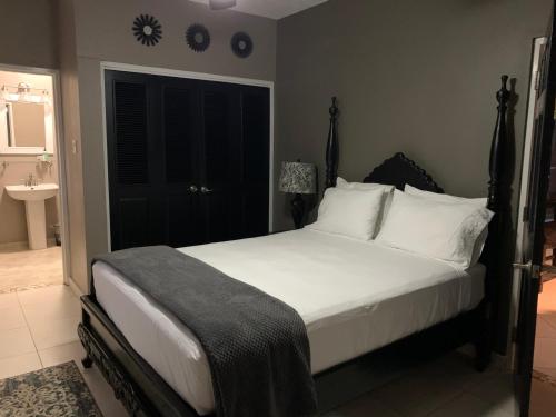 1 dormitorio con 1 cama con sábanas blancas y ventana en CS Domaine Garden Villa - 2 Bedrooms en Port Antonio