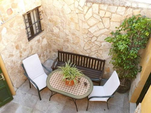 a table and two chairs and a bench on a patio at SOTIO, Village house in Campanet in Campanet